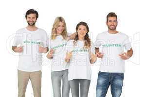 Group portrait of happy volunteers pointing to themselves