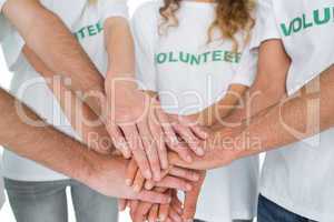 Close-up mid section of volunteers with hands together