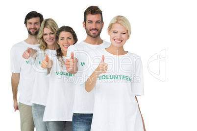 Group portrait of happy volunteers gesturing thumbs up