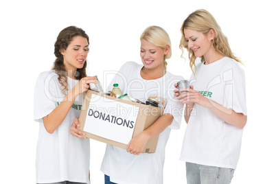 Three smiling young women with donation box