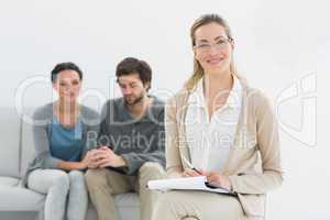 Female financial adviser with young couple in background