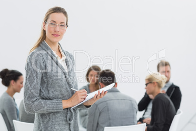 Therapist with group therapy in session in background
