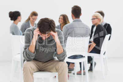 Therapy in session sitting in circle while man in foreground