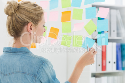 Rear view of a female artist looking at colorful sticky notes