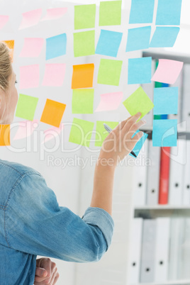 Rear view of a female artist looking at colorful sticky notes