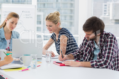 Casual business people around conference table in office