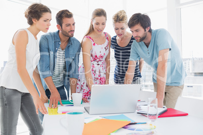 Casual business people using laptop together