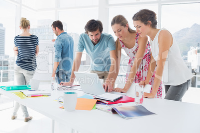 Casual business people using laptop together