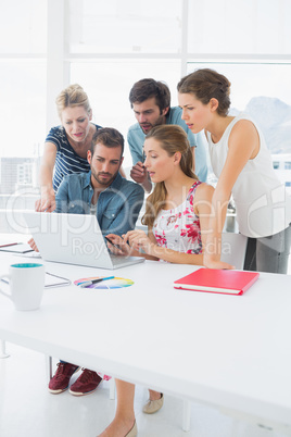 Casual business people using laptop together