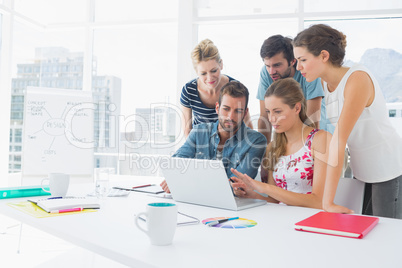 Casual business people using laptop together