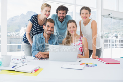 Casual business people using laptop together