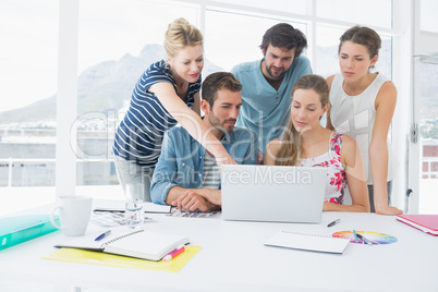 Casual business people using laptop together