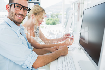 Smiling casual young couple working on computer