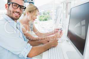 Smiling casual young couple working on computer