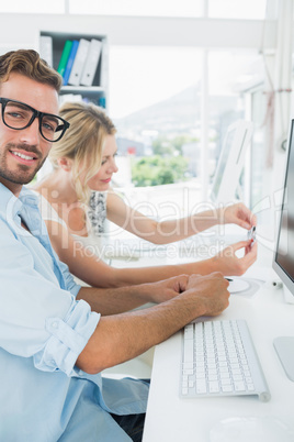 Smiling casual young couple working on computer