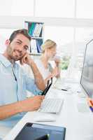 Smiling casual young couple working on computer