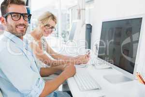 Smiling casual young couple working on computer