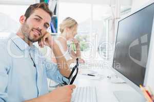 Smiling casual young couple working on computer