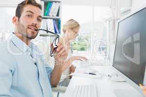 Smiling casual young couple working on computer