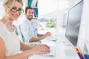 Casual young couple working on computer in office