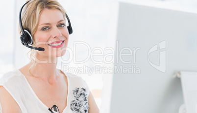 Portrait of a casual woman with headset using computer