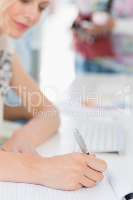 Side view of a casual young woman writing notes