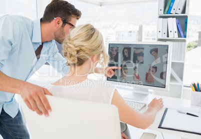 Rear view of photo editors working on computer