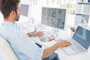 Male photo editor working on computer in a bright office