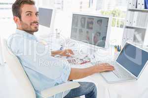 Male photo editor working on computer