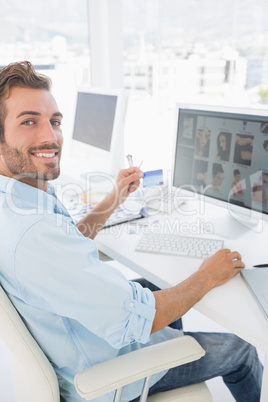 Male photo editor working on computer in office