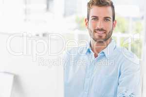 Smiling young man using computer in office