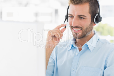 Casual young man with headset using computer