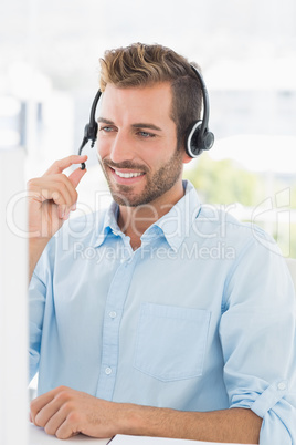 Close-up of a casual young man with headset using computer