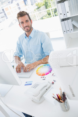 Smiling male photo editor using computer