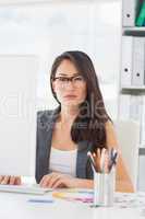 Serious young woman using computer in office