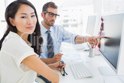 Side view of casual photo editors working on computer