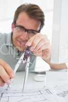 Concentrated man using compass on design