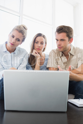 Three young people working on computer