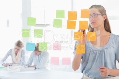 Concentrated artist looking at colorful sticky notes