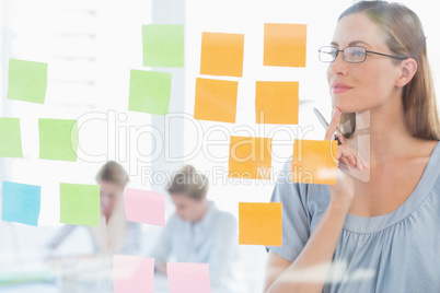 Concentrated artist looking at colorful sticky notes