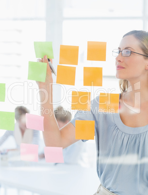 Concentrated artist looking at colorful sticky notes