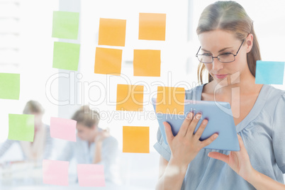 Concentrated artist with digital tablet and colorful sticky note