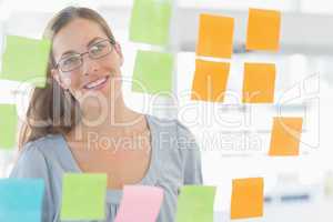 Female artist looking at colorful sticky notes
