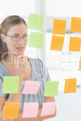 Concentrated artist looking at colorful sticky notes