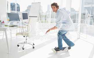 Happy young man skateboarding in a bright office