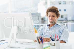 Casual young man using computer in bright office