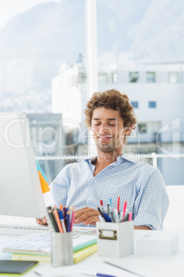 Casual young man using computer in bright office