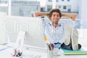 Relaxed casual man with legs on desk in bright office