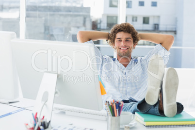 Relaxed casual man with legs on desk in bright office