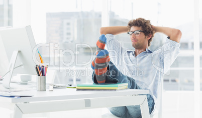 Casual young man with legs on desk in office